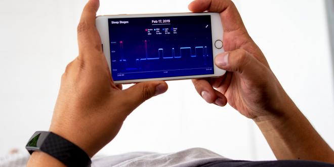 Man laying  monitoring his sleep night with app.