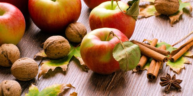 fresh apples, walnuts in the shell, and sticks of cinnamon