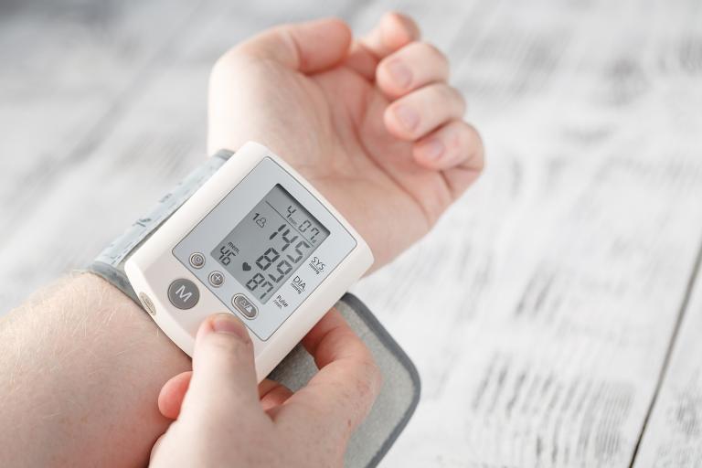 a man checking his blood pressure at home with electronics