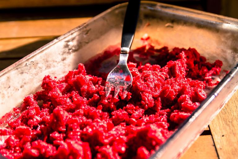 frozen raspberry being mashed and broken up