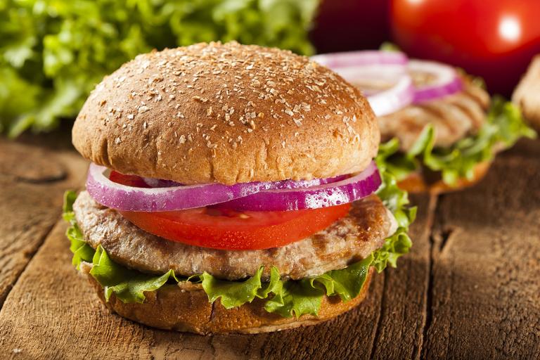 a homemade turkey-meat patty with lettuce, tomato, and onion